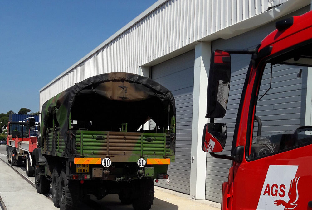 AGS Movers truck parked behind a military vehicle.